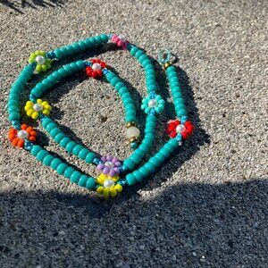 Three colorful turquoise beaded necklaces with daisy chain